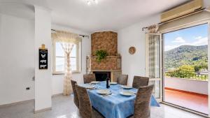 a dining room with a table and chairs and a fireplace at TacchiHousePanorama in Jerzu