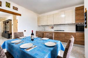 a kitchen with a table with a blue table cloth at TacchiHousePanorama in Jerzu
