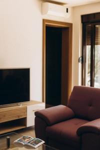 a living room with a couch and a flat screen tv at Carob Breeze House in Krimovice