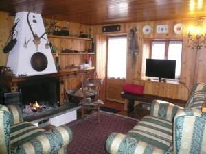 a living room with two couches and a fireplace at Chalet Sheila in Andalo