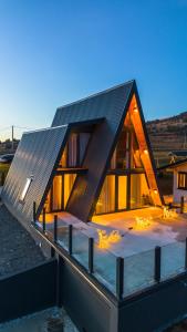 a house with a triangular roof with lights on it at Villa Antonela Kupres in Kupres
