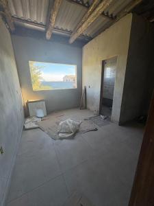 an unfinished room with a painting on the wall at Costa Atlântico House in Garopaba