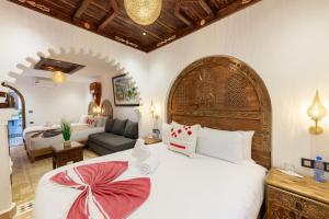 a bedroom with a large bed and a living room at Riad Sultan Chefchaouen in Chefchaouen