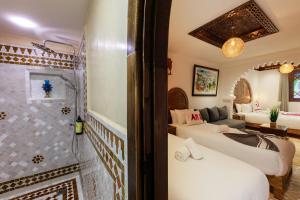 a bathroom with two beds and a shower in a room at Riad Sultan Chefchaouen in Chefchaouen +122 photos