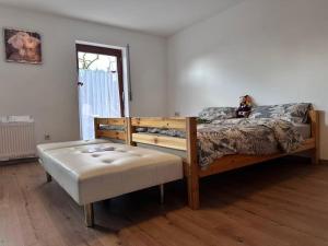 a bedroom with a wooden bed and a ottoman at Traumhaus in Küssaberg