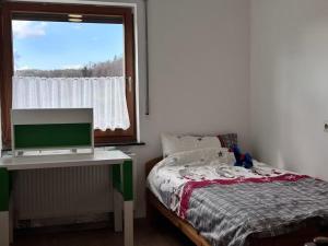 a bedroom with a bed and a window at Traumhaus in Küssaberg +3 photos