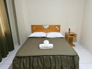 a bedroom with a bed with a towel on it at HOTEL SANTA BARBARA PUERTO ilo in Ilo