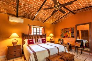 a bedroom with a large bed and a brick wall at Casa del Sol Inn in Ajijic +175 photos