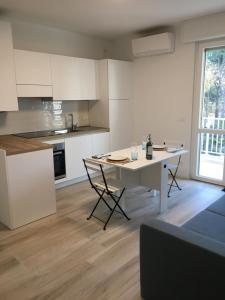 a kitchen with a table and chairs in a room at Studio Artemisia in Grado