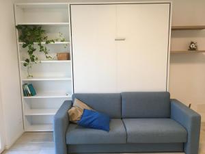 a blue couch with a blue pillow in a room at Studio Artemisia in Grado +19 photos