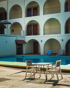 a table and two chairs next to a swimming pool at Hotel Hacienda de Jalpan in Jalpan de Serra