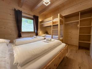 a bedroom with two bunk beds in a log cabin at Wellness Chalet Zirbitz in Lavantegg