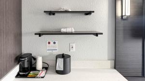 a kitchen with a counter with a coffee maker and shelves at Studio 6 Suites Lexington, Kentucky in Lexington