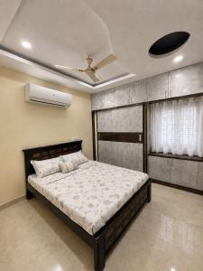 a bedroom with a bed and a ceiling fan at Gachi Ghar Gachibowli 2 BHK in Hyderabad