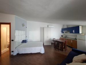 a room with a bed and a kitchen with a table at Suite delle Nereidi in Manarola
