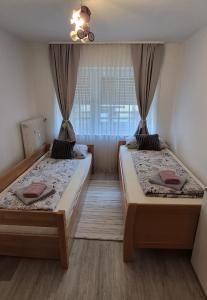 two beds in a small room with a window at Ferienwohnung Alex in Nidderau