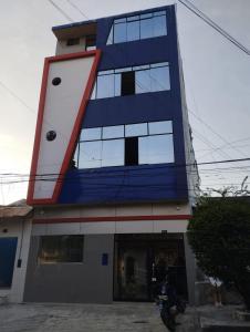 a blue and white building with a motorcycle parked in front at California Bambú in Iquitos