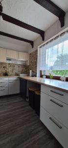 a kitchen with white cabinets and a large window at Ferienwohnung Alex in Nidderau