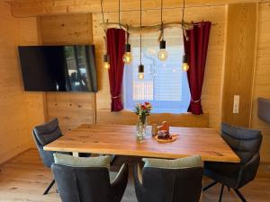 a dining room with a wooden table and chairs at Wellness Chalet Zirbitz in Lavantegg