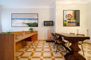 an office with a table and chairs and paintings at DibraLuxurySuites Duomo in Milan