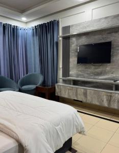 a hotel room with a bed and a flat screen tv at Arizona 2 in Islamabad