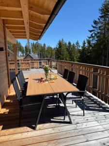 a wooden table and chairs on a deck at Wellness Chalet Zirbitz in Lavantegg
