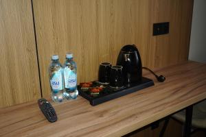 a counter with two bottles of water and a remote control at Alsun Hotel in Astana