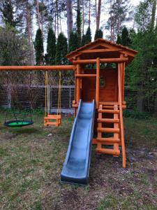 a playground with a slide and a play structure at Forest house with outdoor hot tub in Jūrmala