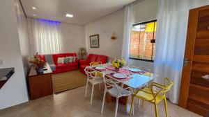 a living room with a table and chairs and a red couch at Casa Amoreira Paraty in Paraty +11 photos