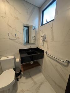 a white bathroom with a sink and a toilet at Pousada Caribdis in Paraipaba +17 photos