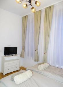 a bedroom with a bed with two pillows and a television at Central Residence Aiud in Aiud +2 photos