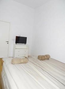 a white bed with two pillows on top of it at Central Residence Aiud in Aiud