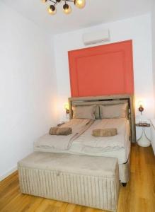 a bedroom with two beds with an orange headboard at Central Residence Aiud in Aiud
