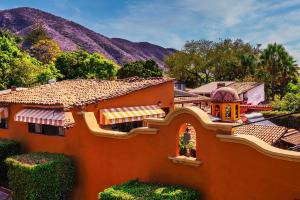 an orange house with a mountain in the background at Casa del Sol Inn in Ajijic