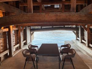 a table and chairs in a room with the ocean at 伊根の舟屋 樹 Funaya Inn Tatsuki , Ine in Kameshima