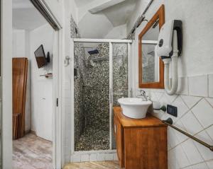 a bathroom with a shower and a white sink at Suite delle Nereidi in Manarola