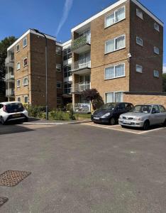 two cars parked in a parking lot in front of a building at Spacious 2 bedroom apartment near Wembley stadium with free parking in London