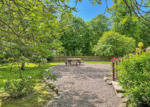 a picnic table in a park with a fence at Glen Clova Lodges in Angus