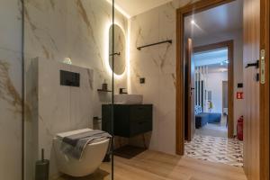 a bathroom with a toilet and a sink and a mirror at Latitude 37 Luxe in Kalamata +37 photos