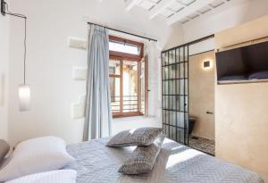 a bedroom with a bed and a tv and a window at Margianna's Cupola Luxury Residence in Rethymno +23 photos