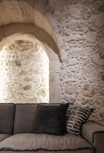 a couch in front of a stone wall at Margianna's Cupola Luxury Residence in Rethymno
