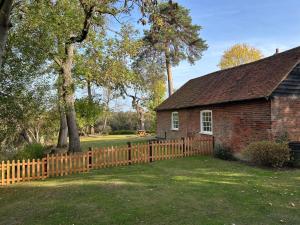 a wooden fence in front of a house at Country Cottage with moat in Ingatestone