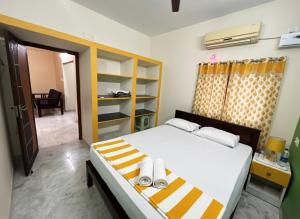 a bedroom with a bed with white and yellow stripes at De Majestic SSK Paradise Beach Villa in Pondicherry