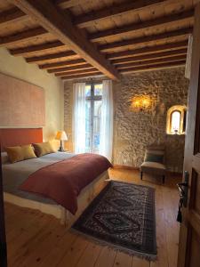 a bedroom with a bed and a stone wall at Le patio de Collias in Collias +26 photos