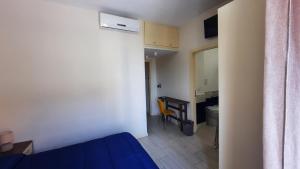 a room with a bed and a desk and a table at BrezzaMarina in Sapri