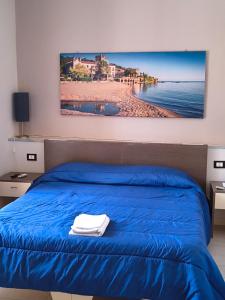 a bedroom with a blue bed and a view of the beach at BrezzaMarina in Sapri
