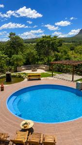 a large swimming pool with chairs and a table at Recanto Arco Íris in Palmeiras