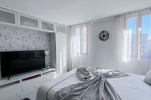 a bedroom with a tv and a stuffed animal on a bed at Domus Via Domitia in Narbonne