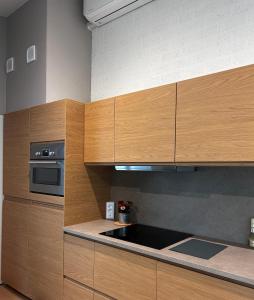 a kitchen with wooden cabinets and a microwave at Cosy 26 - Zuid-Limburg in Simpelveld