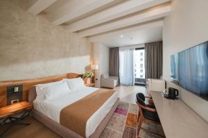 a hotel room with a bed and a flat screen tv at Chic Boutique Hotel Vlore in Vlorë